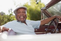 Улыбающийся пожилой мужчина за рулем кабриолета — стоковое фото