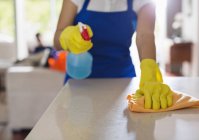 Immagine ritagliata della donna pulizia bancone della cucina — Foto stock