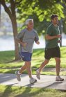 Мужчины бегают вместе в парке — стоковое фото