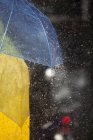 Крупним планом людини під парасолькою під дощем — стокове фото