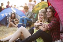 Couple hugging outside tent at music festival — Stock Photo
