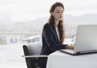 Бизнесмен, использующая ноутбук в офисе — стоковое фото