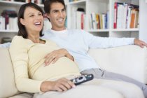 Couple watching television on sofa — Stock Photo