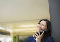 Бизнесвумен разговаривает по телефону в современном офисе — стоковое фото