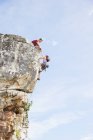 Pareja de escaladores escalando empinada cara de roca - foto de stock