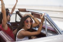 Усміхнені жінки керують кабріолетом — стокове фото