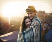 Пара завернутых в одеяло снаружи палаток на музыкальном фестивале — стоковое фото