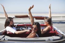 Mujeres animando en coche descapotable - foto de stock