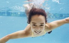 Menina caucasiana feliz nadando na piscina — Fotografia de Stock