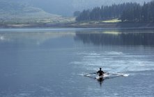 Uomo canottaggio scull sul lago — Foto stock