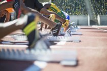 Runners poised at starting blocks on track — Stock Photo