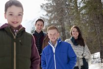 Porträt einer lächelnden Familie im verschneiten Wald — Stockfoto