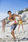 Felice uomo caucasico giocare a cricket in spiaggia — Foto stock