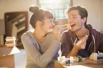 Couple eating sushi together in new home — Stock Photo