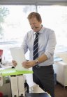 Бізнесмен тримає папки в сучасному офісі — стокове фото