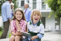 Kinder nutzen gemeinsam digitales Tablet im Freien — Stockfoto