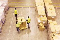 Trabajadores que cargan cajas en el almacén - foto de stock