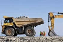 Workers and machinery in quarry — Stock Photo