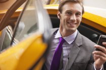 Бизнесмен вылезает из такси — стоковое фото
