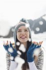 Щаслива жінка дивиться, як падає сніг — стокове фото