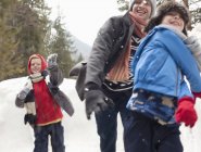 Отец и сыновья наслаждаются снежным поединком — стоковое фото