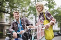 Couple standing on bicycles on city street — Stock Photo
