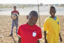 Chicos africanos sonriendo en el campo de tierra - foto de stock