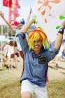Playful men cheering in wigs at music festival — Stock Photo