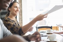 Geschäftsfrau teilt bei Treffen im Café Dokumente aus — Stockfoto