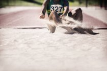 Long jumper pouso na areia — Fotografia de Stock