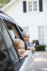 Older woman and granddaughter leaning out car windows — Stock Photo