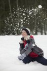 Портрет счастливого мальчика, наслаждающегося снежным поединком — стоковое фото