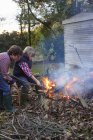 Vista lateral de meninos construindo fogueira no quintal — Fotografia de Stock