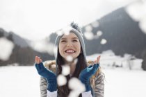 Щаслива жінка насолоджується падаючим снігом у полі — стокове фото