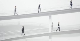 Pessoas de negócios caminhando ao longo da passarela elevada — Fotografia de Stock