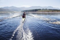 Rowing crew rowing scull on lake — Stock Photo