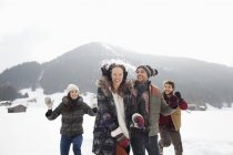 Играющие друзья, наслаждающиеся боем снежков в поле — стоковое фото