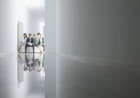 Portrait of business people sitting in circle in corridor — Stock Photo