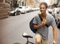 Homem andando de bicicleta na rua da cidade com walkie-talkie — Fotografia de Stock