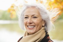 Smiling older woman standing in park — Stock Photo
