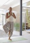 Ältere Frau praktiziert Yoga zu Hause — Stockfoto