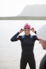 Confident and strong triathletes adjusting goggles outdoors — Stock Photo