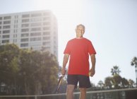 Older man playing tennis on court — Stock Photo