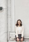 Portrait of smiling businesswoman leaning against building wall — Stock Photo