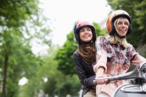 Mulheres andando em scooter juntos ao ar livre — Fotografia de Stock