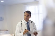 Doctor writing on clipboard in modern hospital — Stock Photo