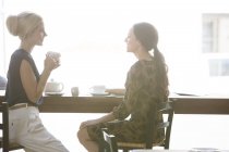 Жінки з кавою разом у кафе — стокове фото