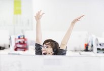 Mujer de negocios en auriculares animando en el escritorio en la oficina moderna - foto de stock
