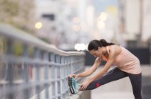 Frau dehnt sich vor Sport auf Stadtstraße — Stockfoto
