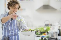 Uomo che fa insalata in cucina — Foto stock